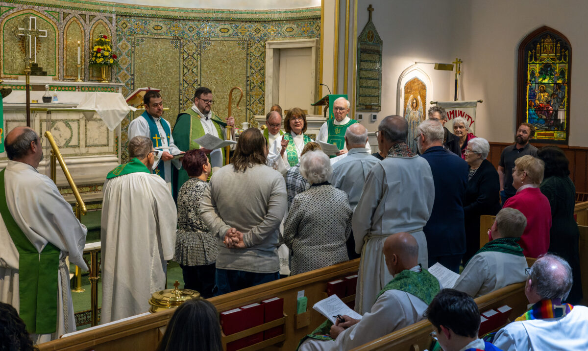 Beck preaches in a church, surrounded by ministers and other members of the congregation.