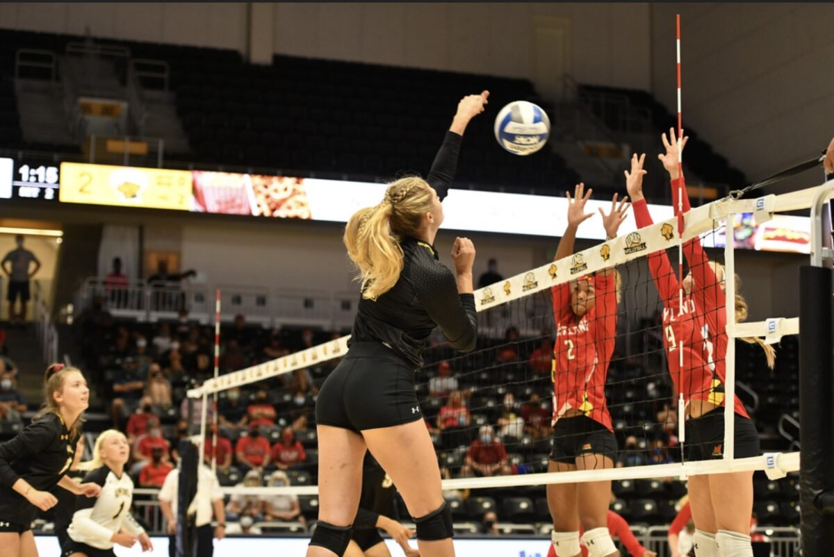 A group of women play volleyball