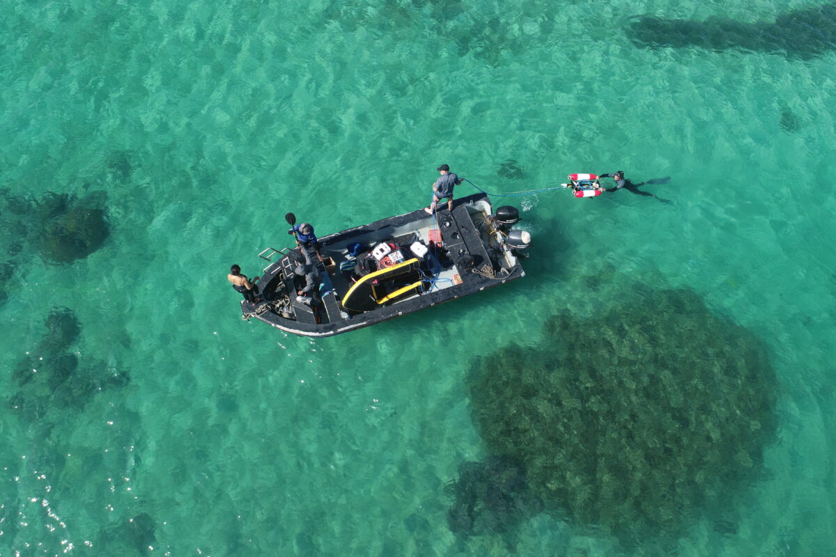 A bird's-eye view of Smith and his team working on a boat at sea studying ocean life.