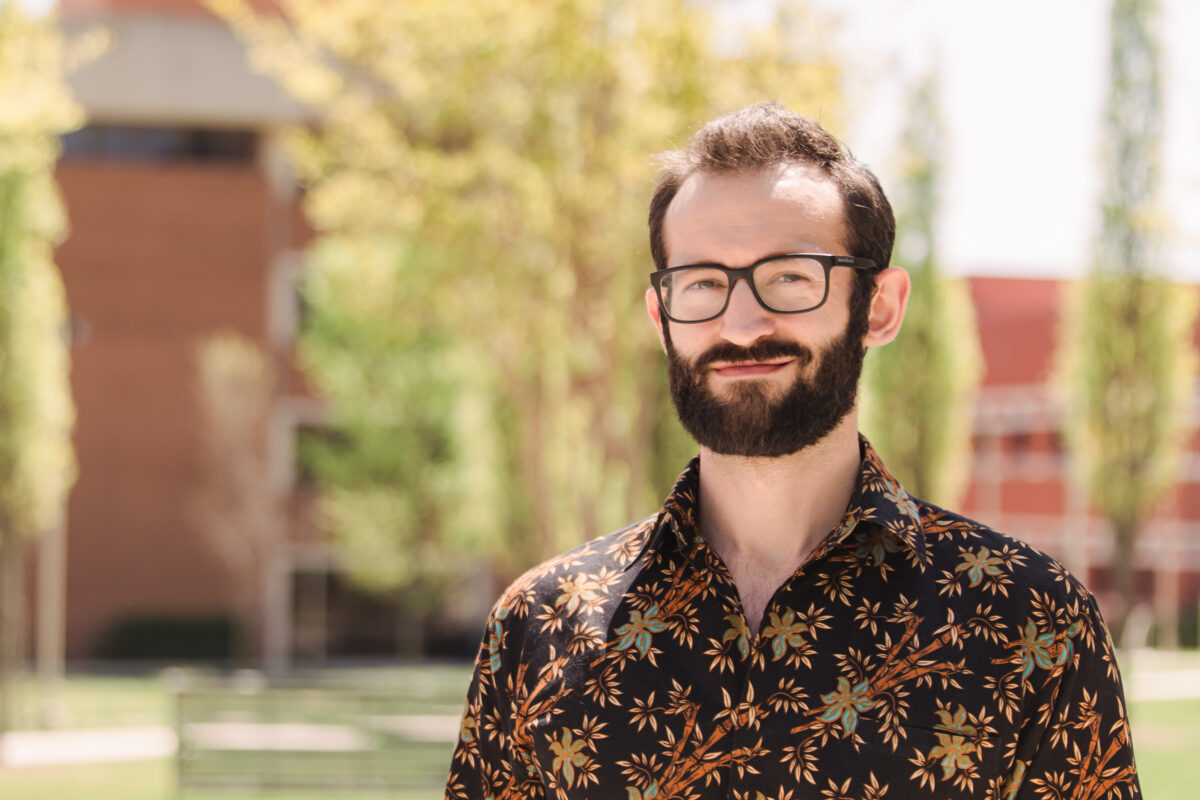 Headshot of a UMBC grad student who has a beard and wears glasses on campus.