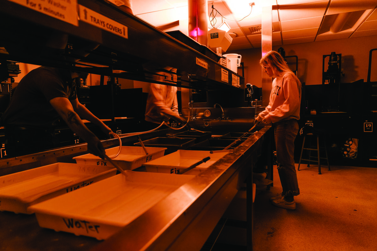 Students work in a photography darkroom.