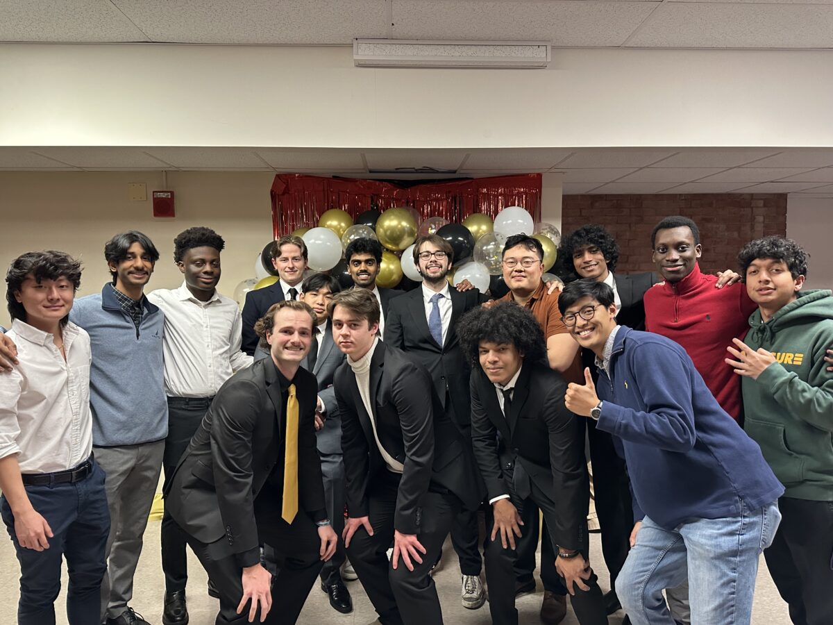 15 members of the Pi Kappa Phi fraternity on UMBC's campus with arms around one another, smiling and posing for a picture.  