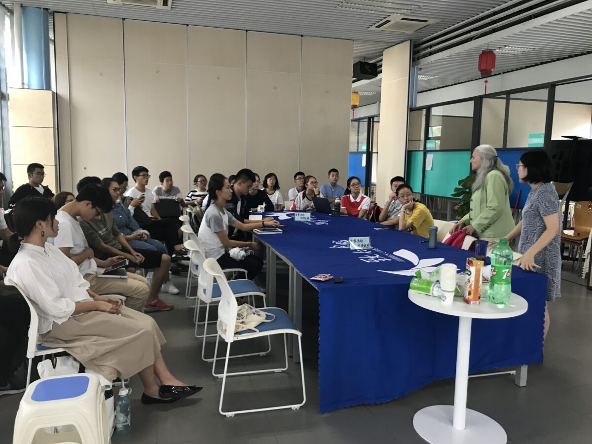 Two women speak to a classroom of Chinese students about English language learning.