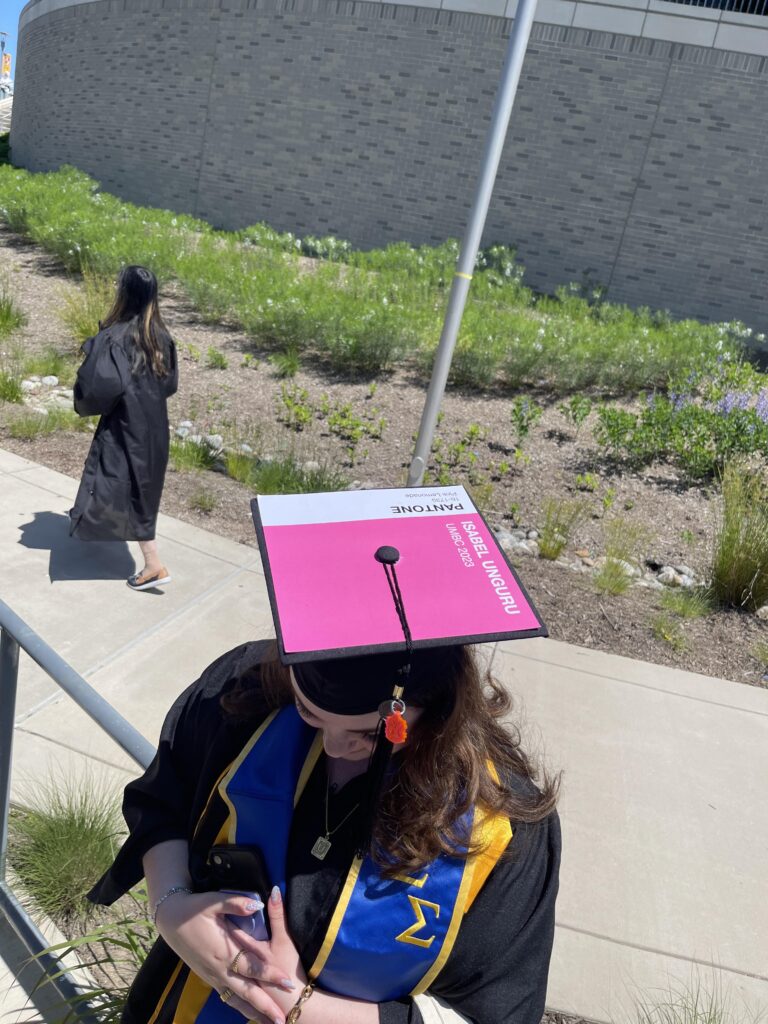 A graduating student displays her decorated pink cap.