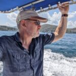 Terry Smith stands in a boat at sea working to change the effects of climate change on ocean life.