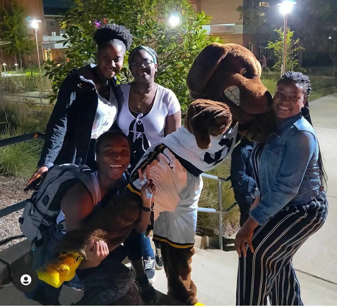 Group of students pose with mascot dog.