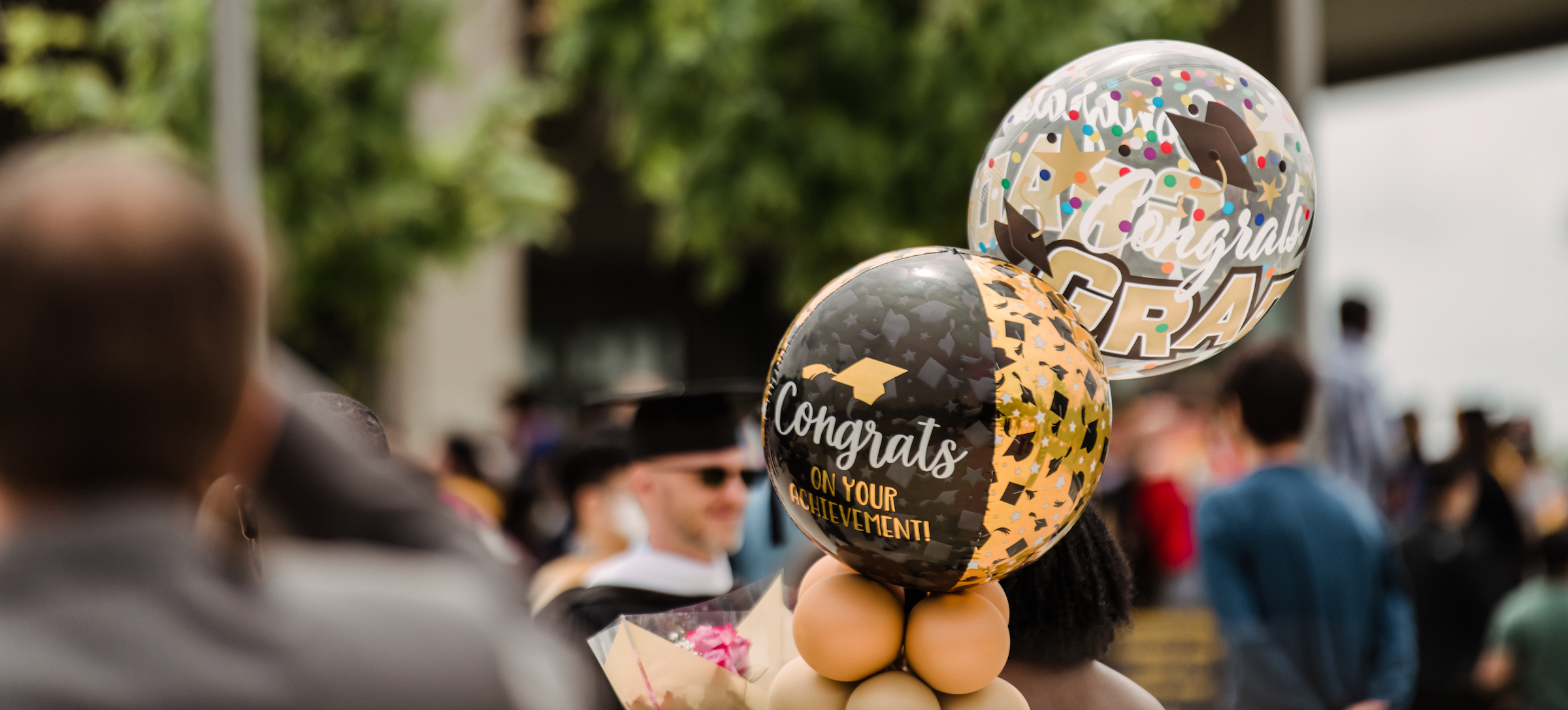 Gold and black balloons read "Congrats Grad" and "Congratulations on your achievements"