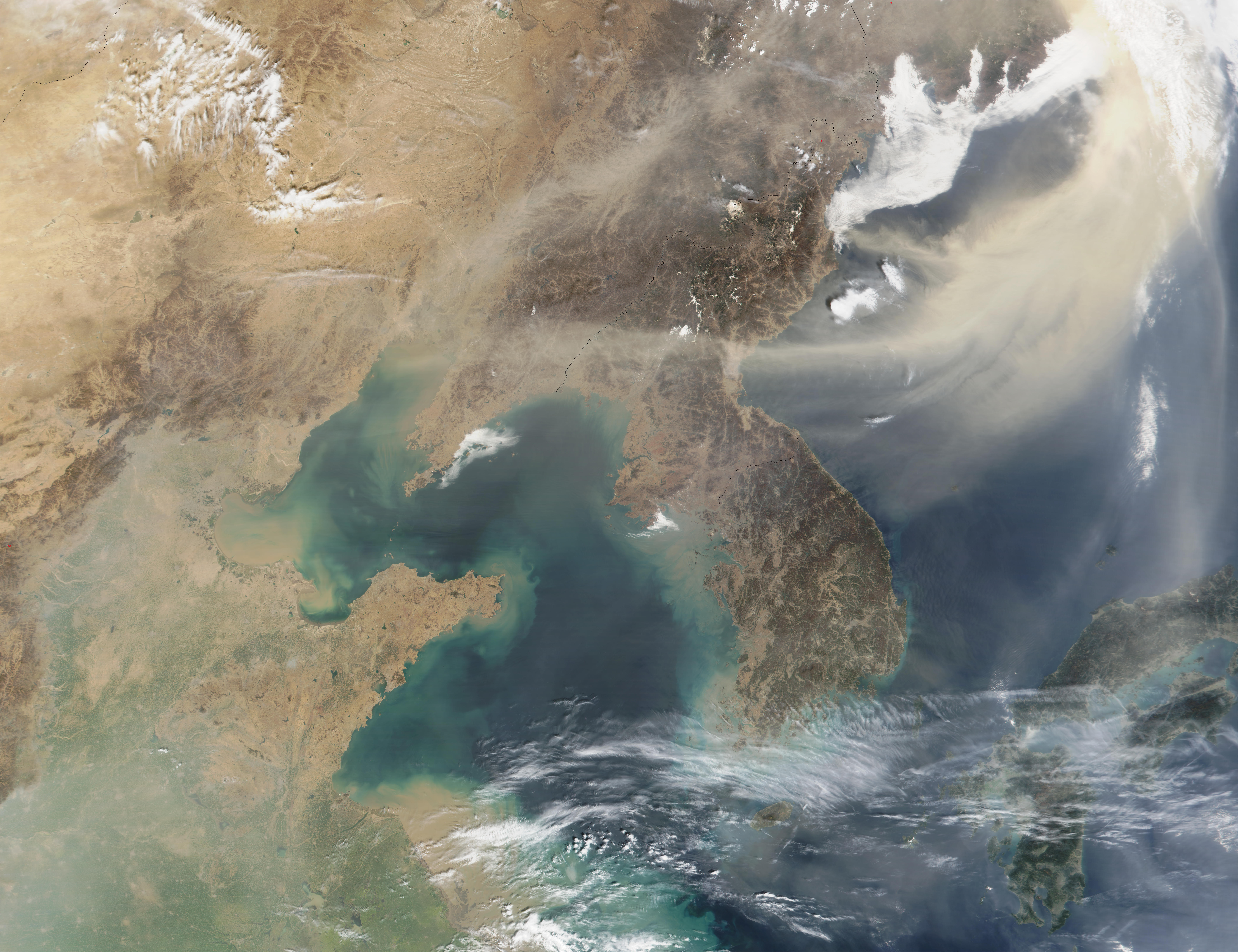 Satellite image with the Korean peninsula in the center; tan atmospheric dust is seen sweeping across to the northeast