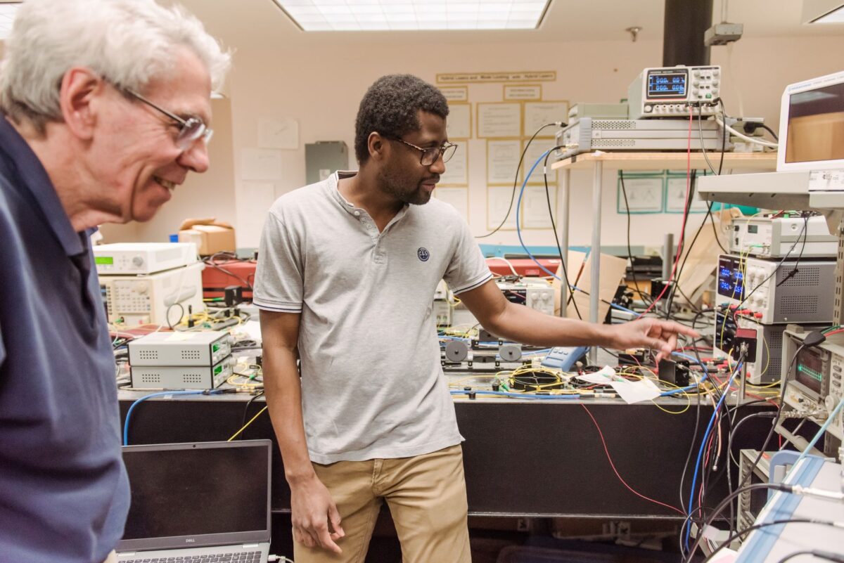 Two people look at electronic equipment.