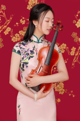 Against a red background, a woman with dark hair cradles a violin