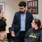 Three alumni coaches talk with the mock trial team