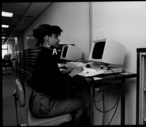 A woman works on a 1980s computer.