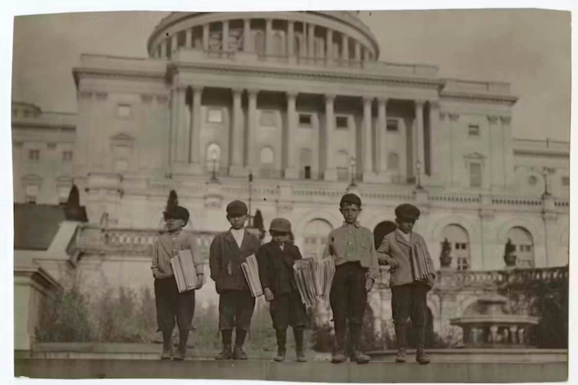 Lewis Wickes Hine, ‘Group of newsies selling on Capitol steps, April 11, 1912.’ Four young boys holding newspapers.