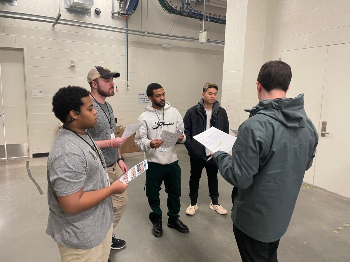 a group of students gather in a hallway to go over instructions