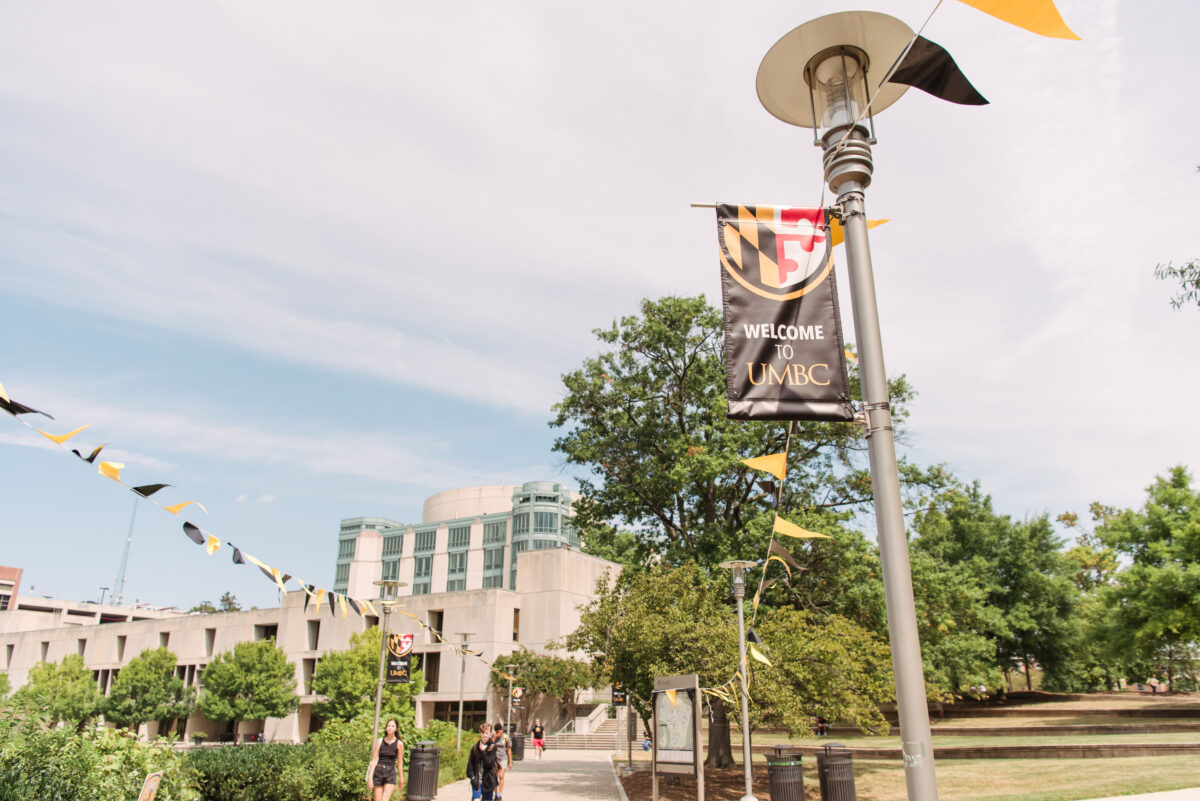 Light post with UMBC banner attached and black and gold flags drawn across