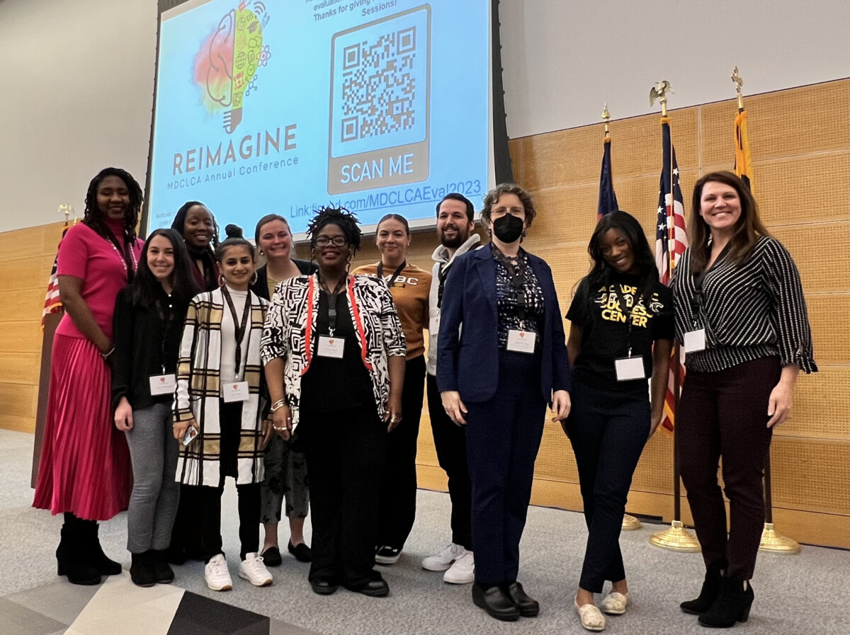 a group of presenters, peer tutors, and SI PASS representatives stand in front of a screen