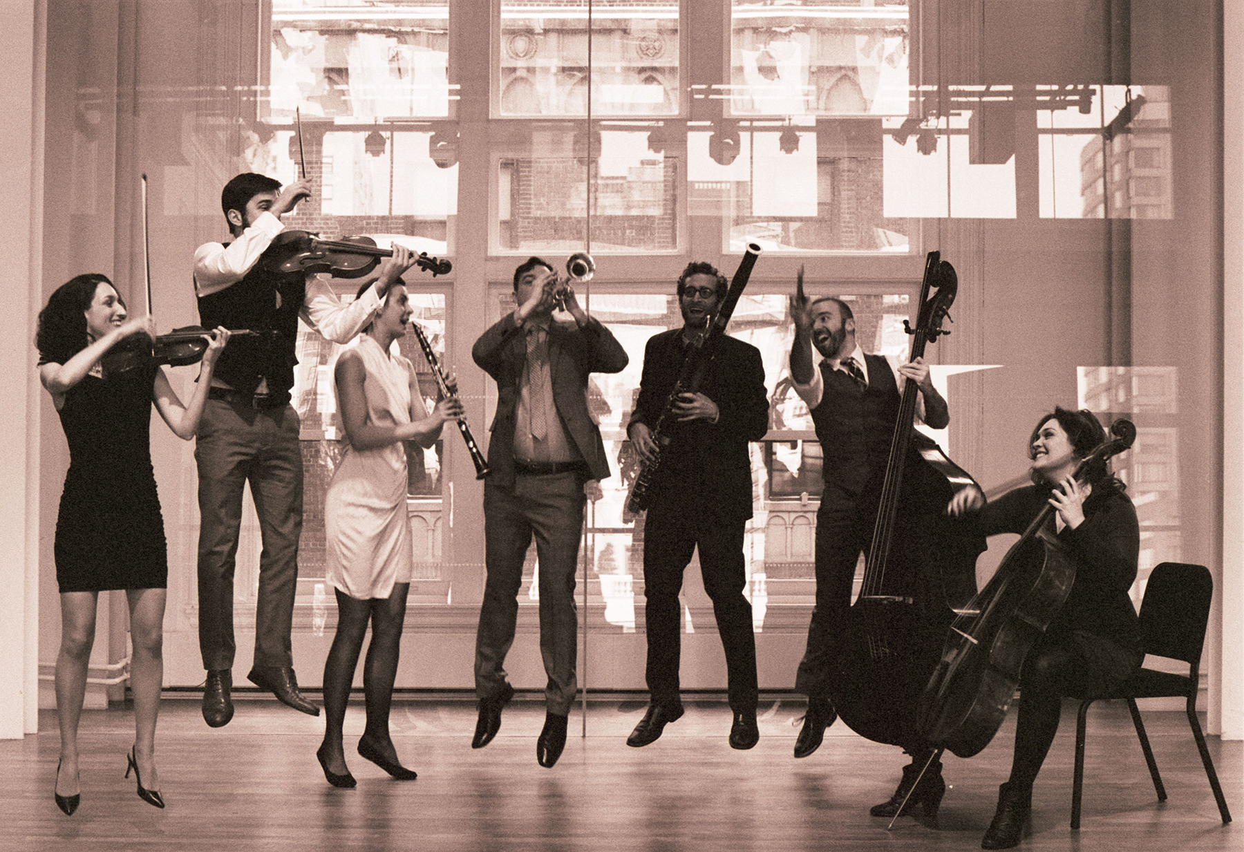In a sepia-toned photos, a group of seven musicians with instruments
