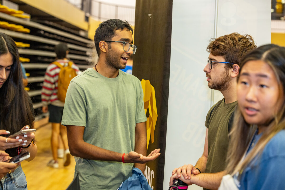 Two students talk to each other in a gymnasium