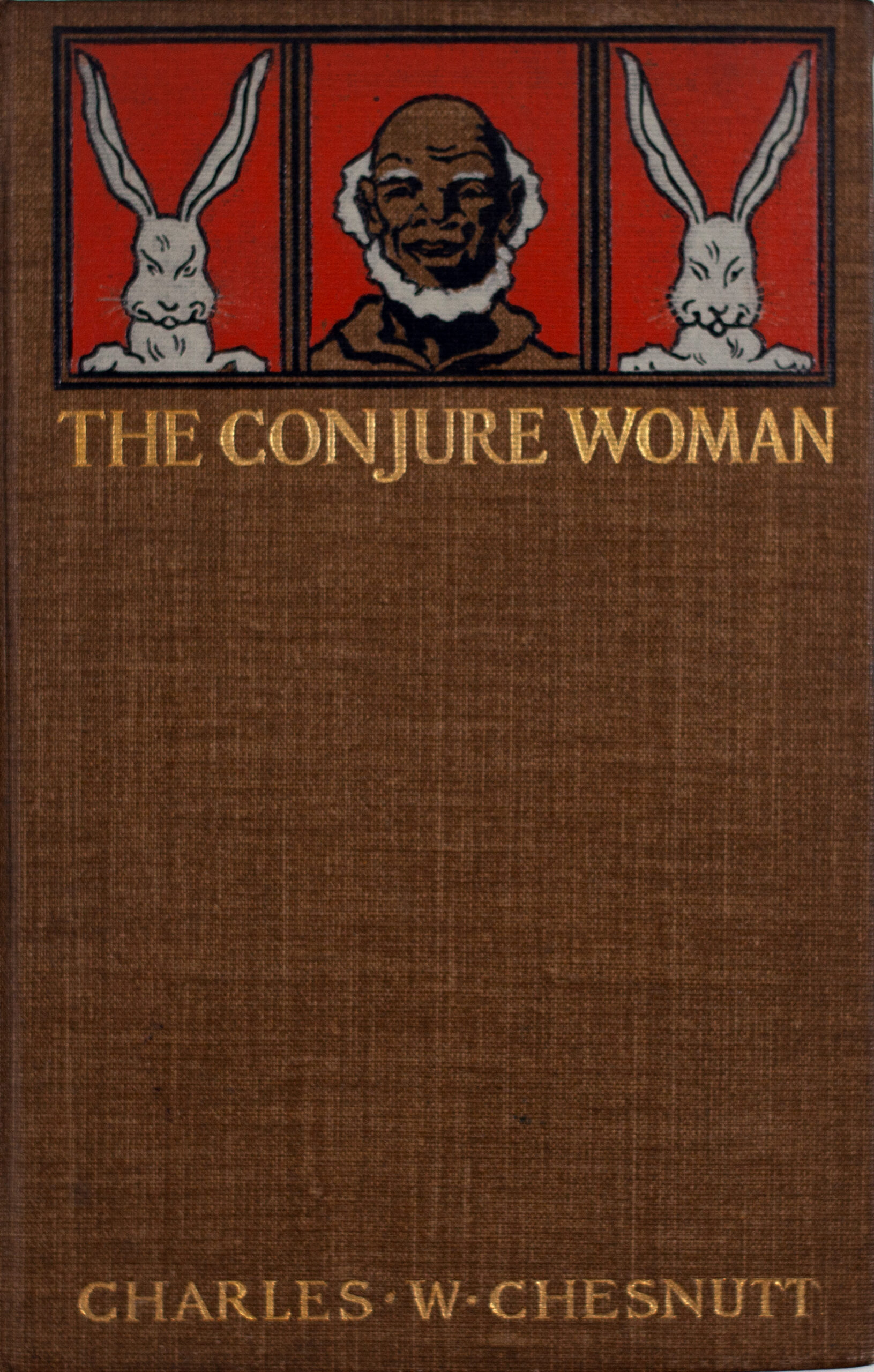 An antique book cover says The Conjure Woman by Charles W Chesnutt