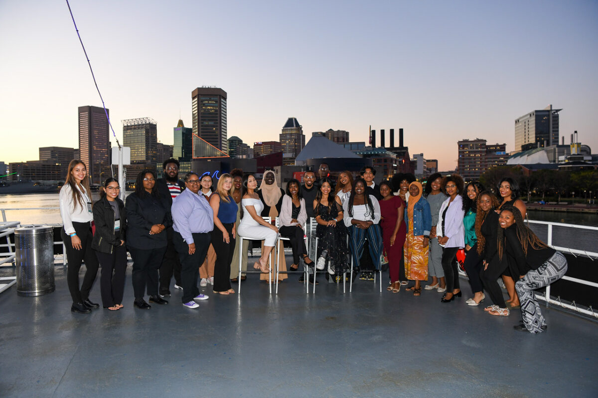 A group of McNair scholars pose against the sunset in the baltimore harbor