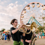 musicians play in front of a carnival at homecoming