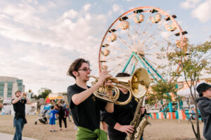 musicians play in front of a carnival at homecoming