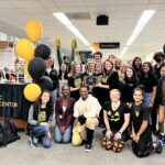 students dressed in black and gold celebrate at the academic success center