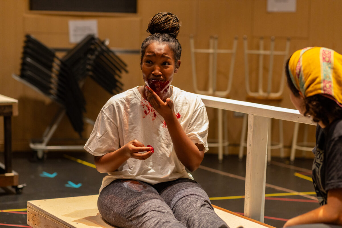 a student smears stage blood on themselves in rehearsal