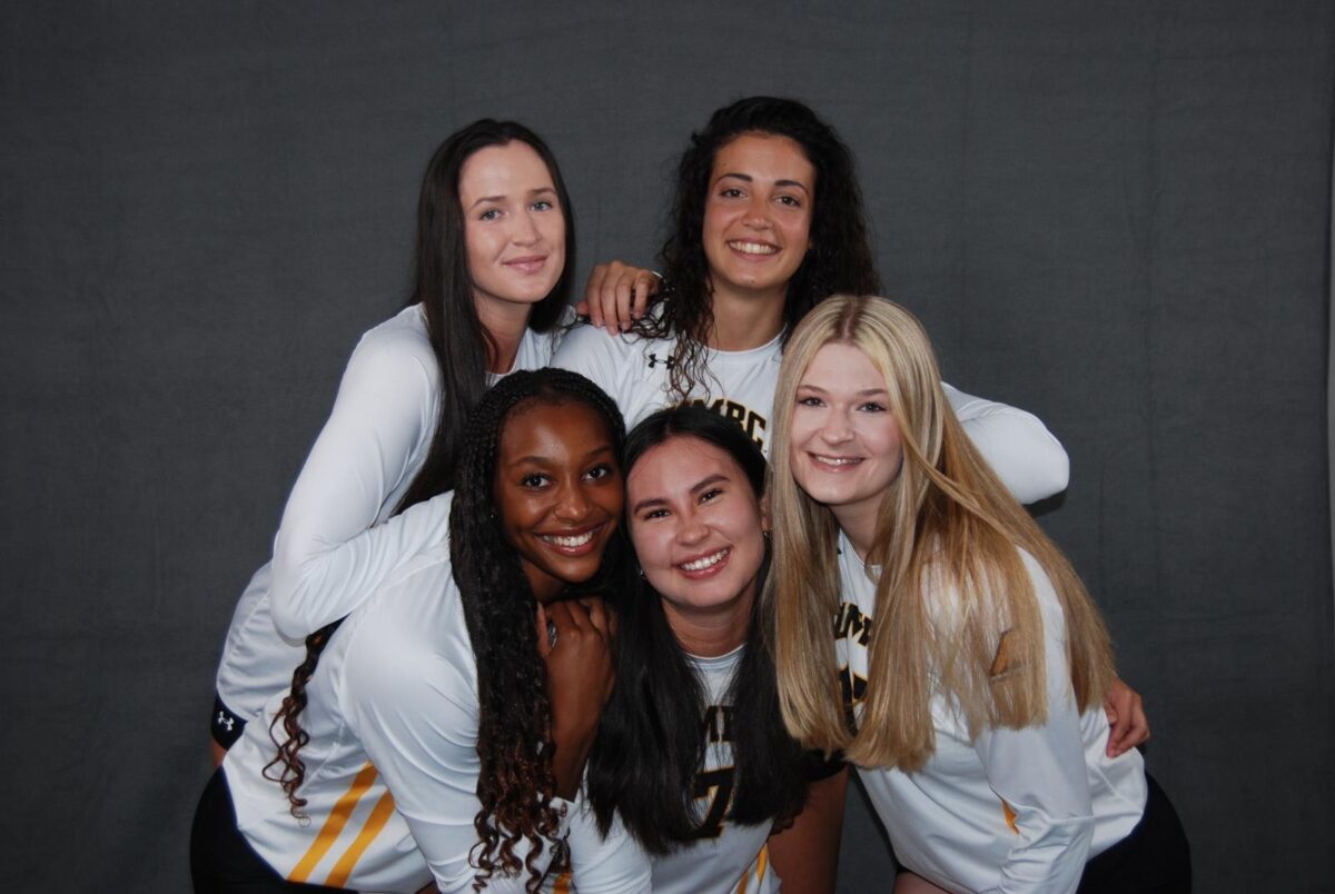 members of the volleyball team pose together