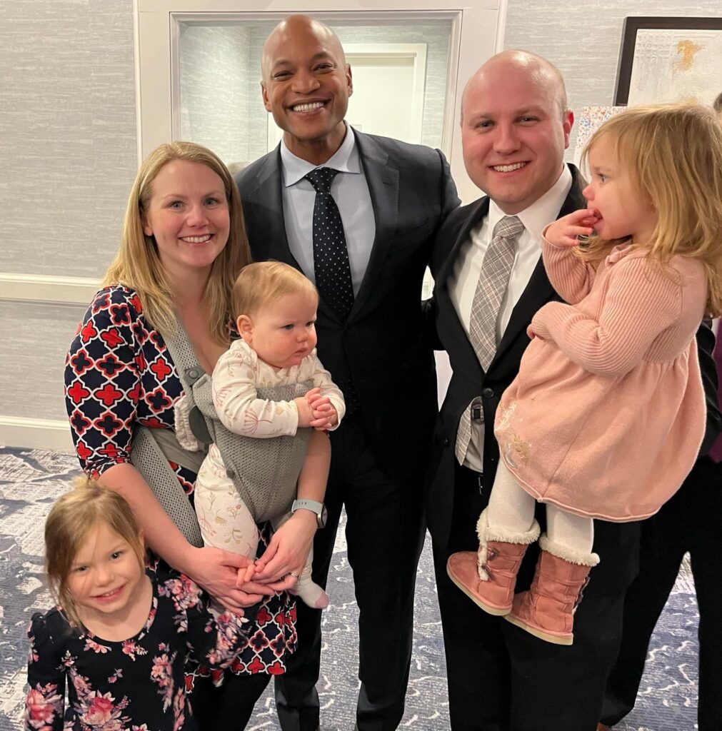 A man, woman, and three young girls standing with Maryland Governor Wes Moore.