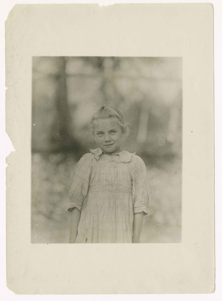 a little girl stands in a faded historical photo