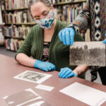 Meredith Power, left, and Susan Graham, right, handle the century-old photographs.