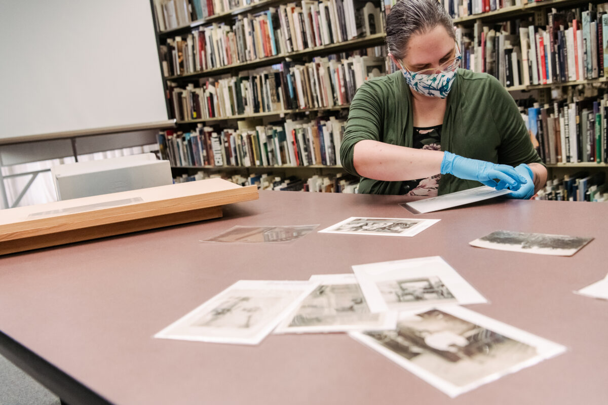 an intern puts historical photos into a mylar sleeve