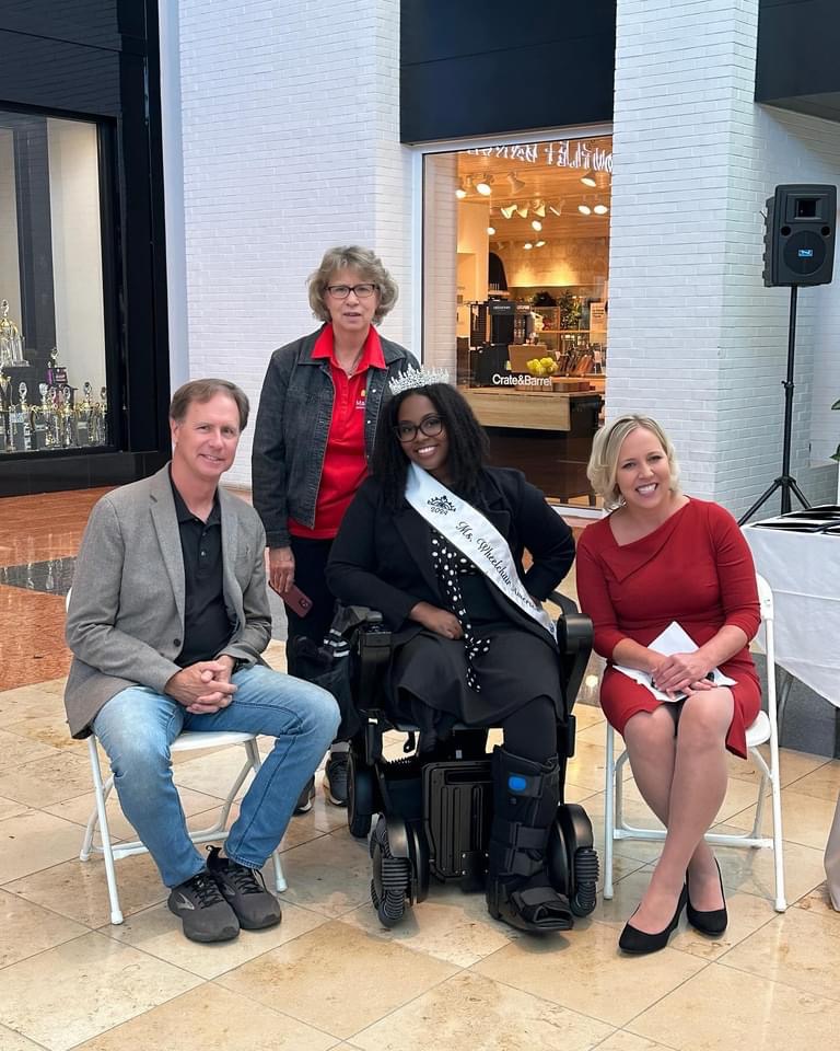 four people pose, in the center is 2024 Ms Wheelchair America, a spokesperson for accessibility for all
