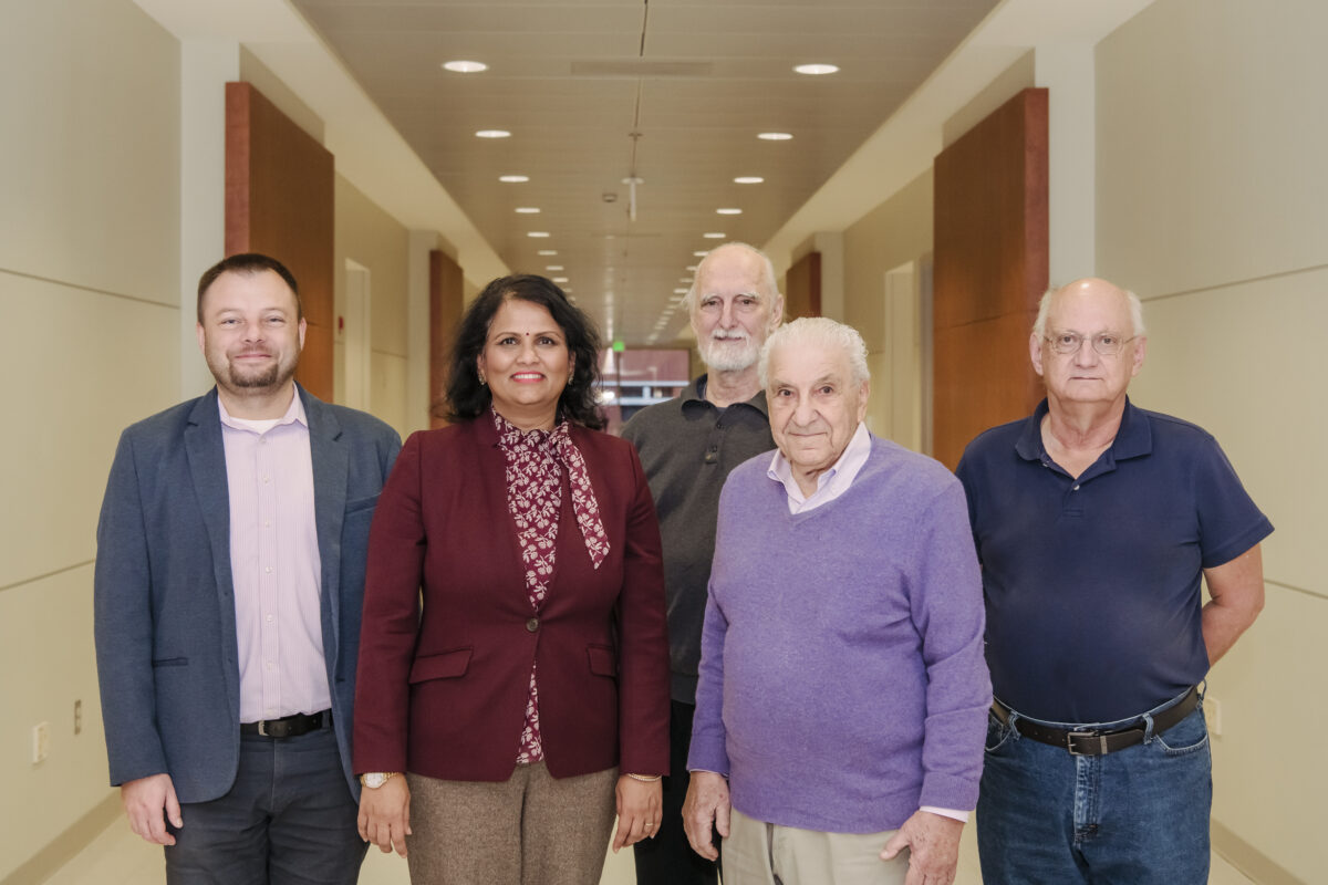 UMBC's CARTA Phase II faculty team (five people) posing for a photo in a hallway of one of UMBC's academic buildings. 