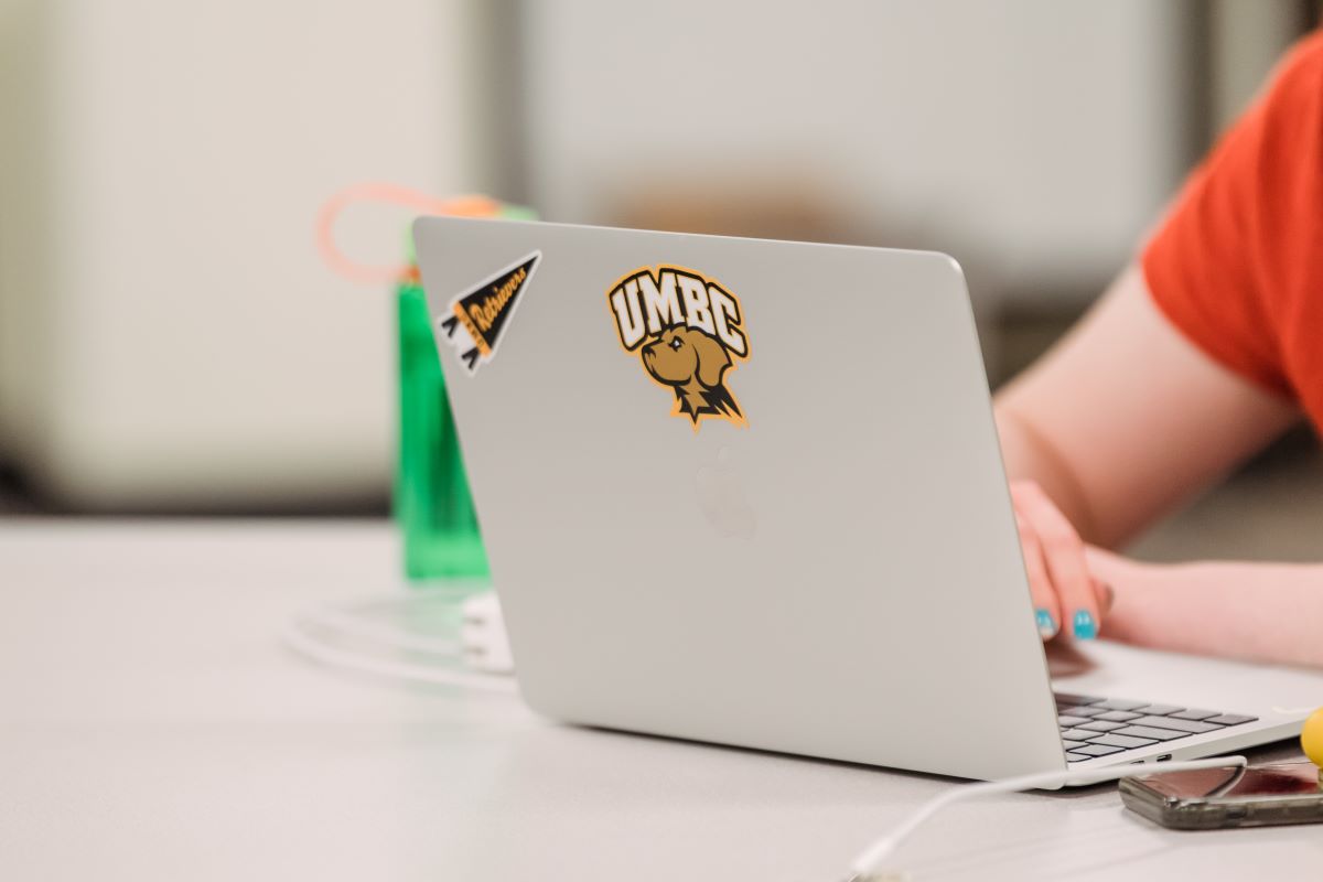Back of laptop computer shows UMBC logo.