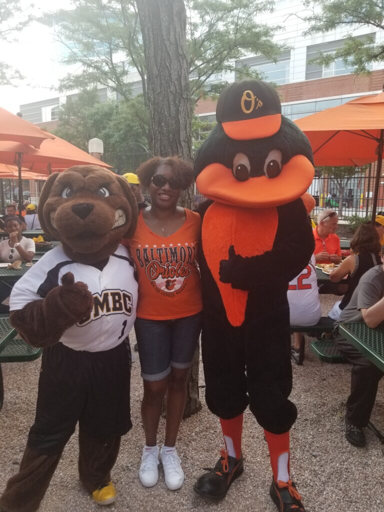 Monique Cephas with True Grit and the Oriole Bird at the UMBC Alumni Association night at Camden Yards.