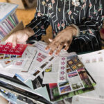 A woman sorts through many postage stamps for her pen pal hobby