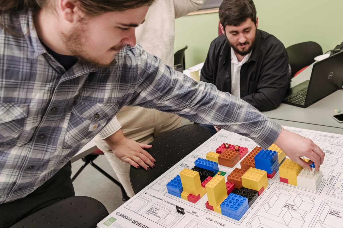 A college student works on a LEGO city layout.