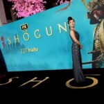 Television celebrities walking across a black carpet with the word Shōgun written in gold