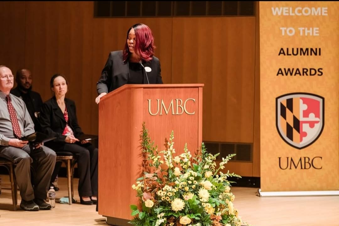 Kisha Parker standing at the UMBC Alumni Awards podium.