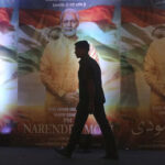 A man walks past posters of the film ‘PM Narendra Modi,’ a biopic on the Indian prime minister, during its launch in Mumbai, India,