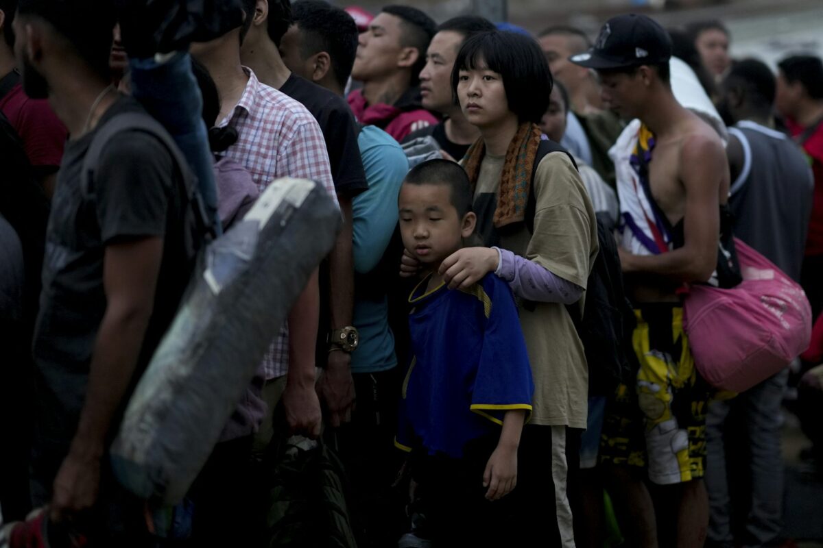 A large group of Chinese migrants stand in line