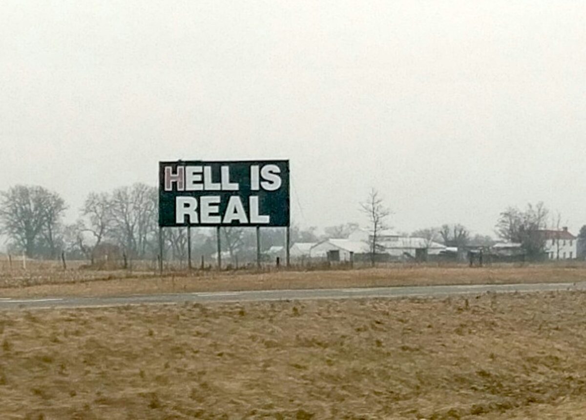A large bill board in the middle of a field reads Hell is Real