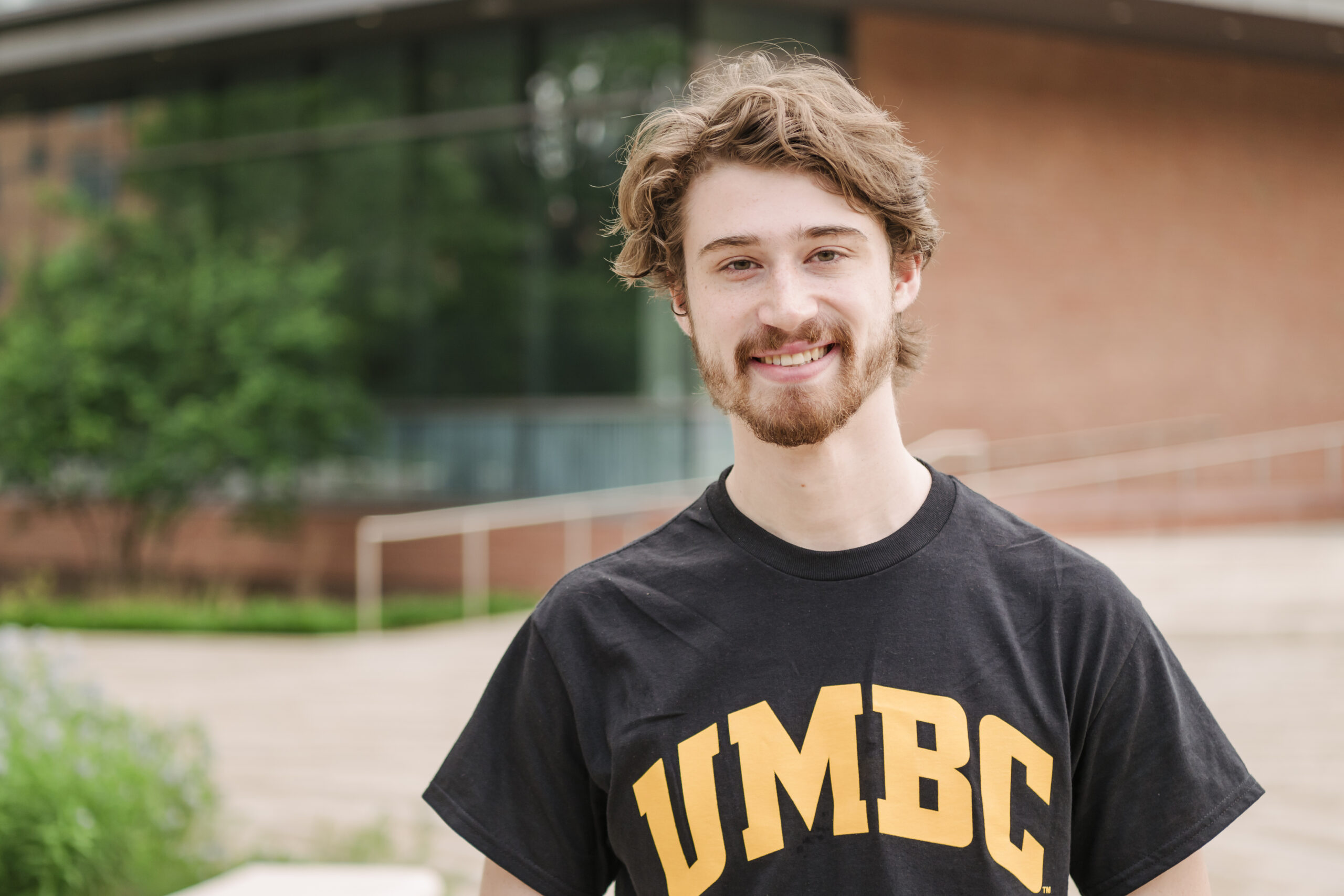 portrait of student standing outside, wearing UMBC t-shirt