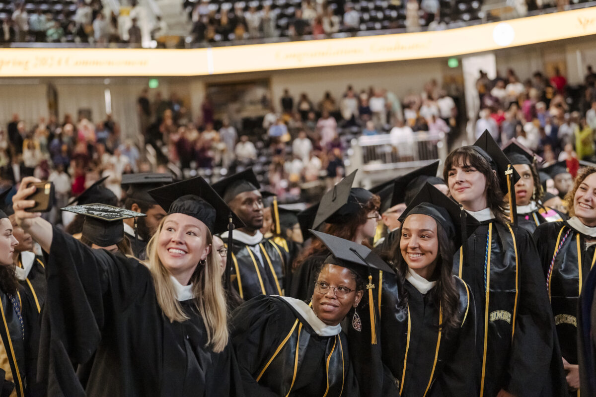 UMBC Class of 2024 graduates smiling and posing for a selfie. 