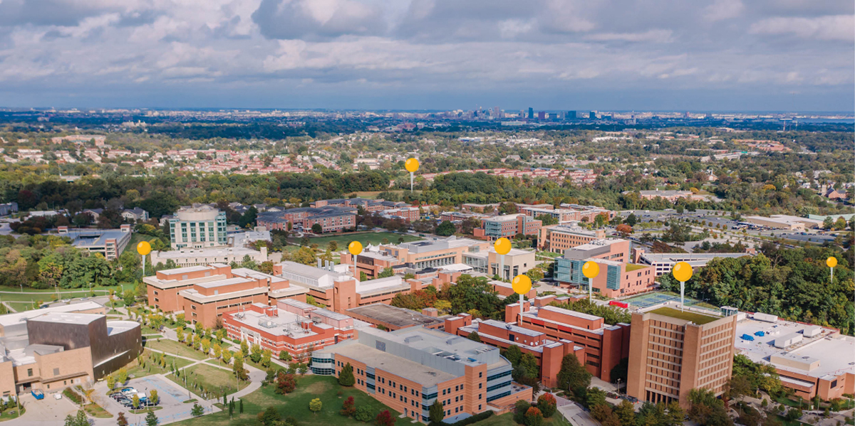 UMBC's campus from a bird's eye view, with gold location pegs superimposed the image to indicate research zones