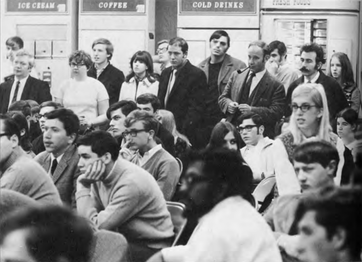 Audience members watching a performance inside a coffee house.
