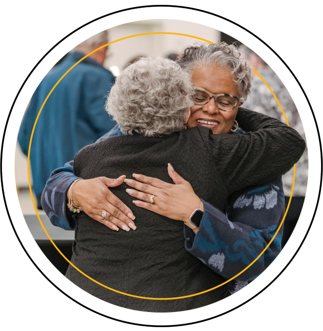Diane Lee hugs Pamela Morgan, the former director of the Office of Field Experiences and Clinical Practice in UMBC’s education department and a Wisdom Institute Board Member.