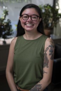 a woman in sleeveless shirt and glasses